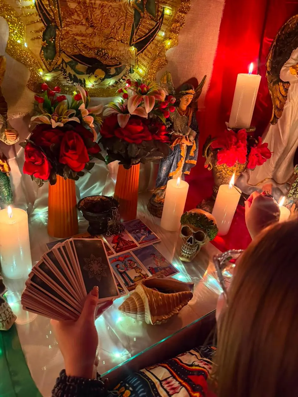 Maestra barajando las cartas del tarot en el altar