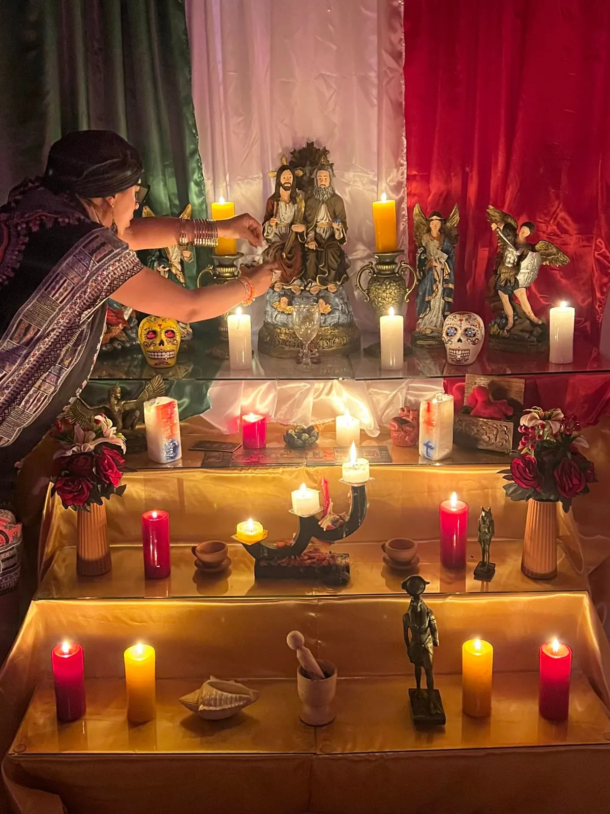 Altar del templo con santos, velas y calaveras